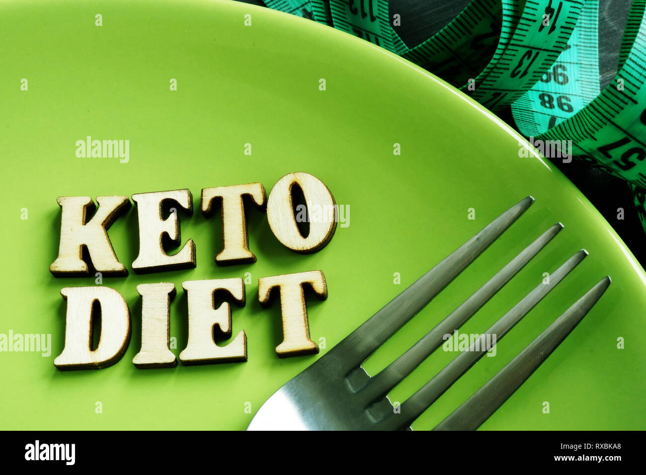 Keto Diät auf der grünen Platte und Maßband. Stockfoto
