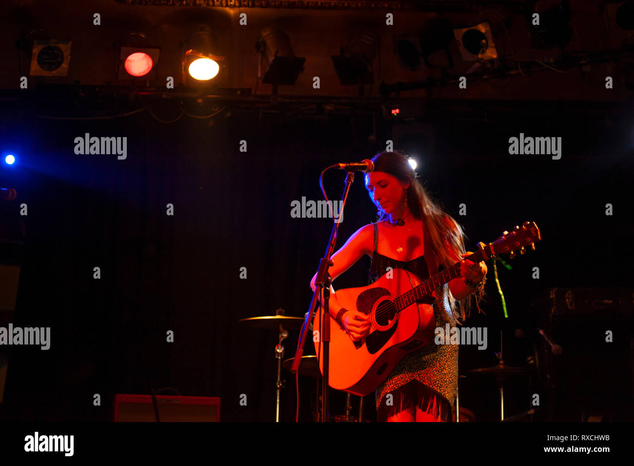 Sängerin mit akustischer Gitarre spielen auf der Bühne Stockfoto