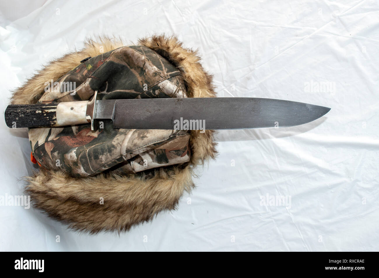Ein Big Mountain man Bowie Messer auf einem warmen furry Hut mit einem weißen Hintergrund angezeigt. Stockfoto
