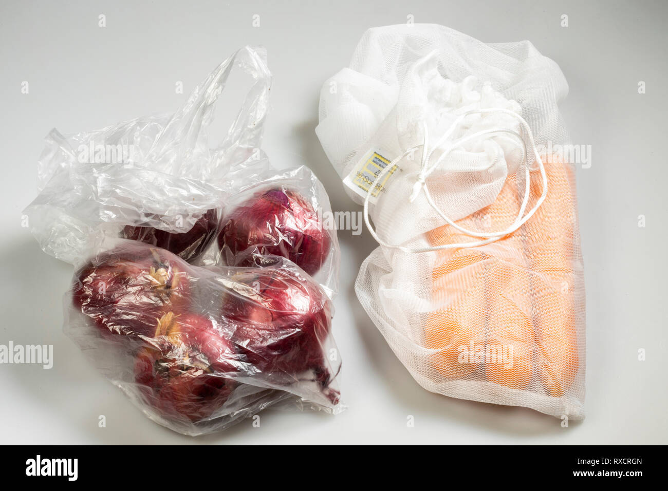 Verpackungen für Lebensmittel, Karotten in einer wiederverwendbaren Kunststoff net, Vermeidung von plastik Müll, Zwiebeln in eine wiederverwendbare Tasche, Stockfoto