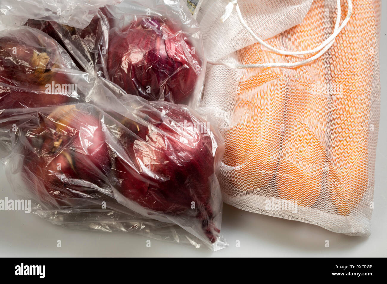 Verpackungen für Lebensmittel, Karotten in einer wiederverwendbaren Kunststoff net, Vermeidung von plastik Müll, Zwiebeln in eine wiederverwendbare Tasche, Stockfoto