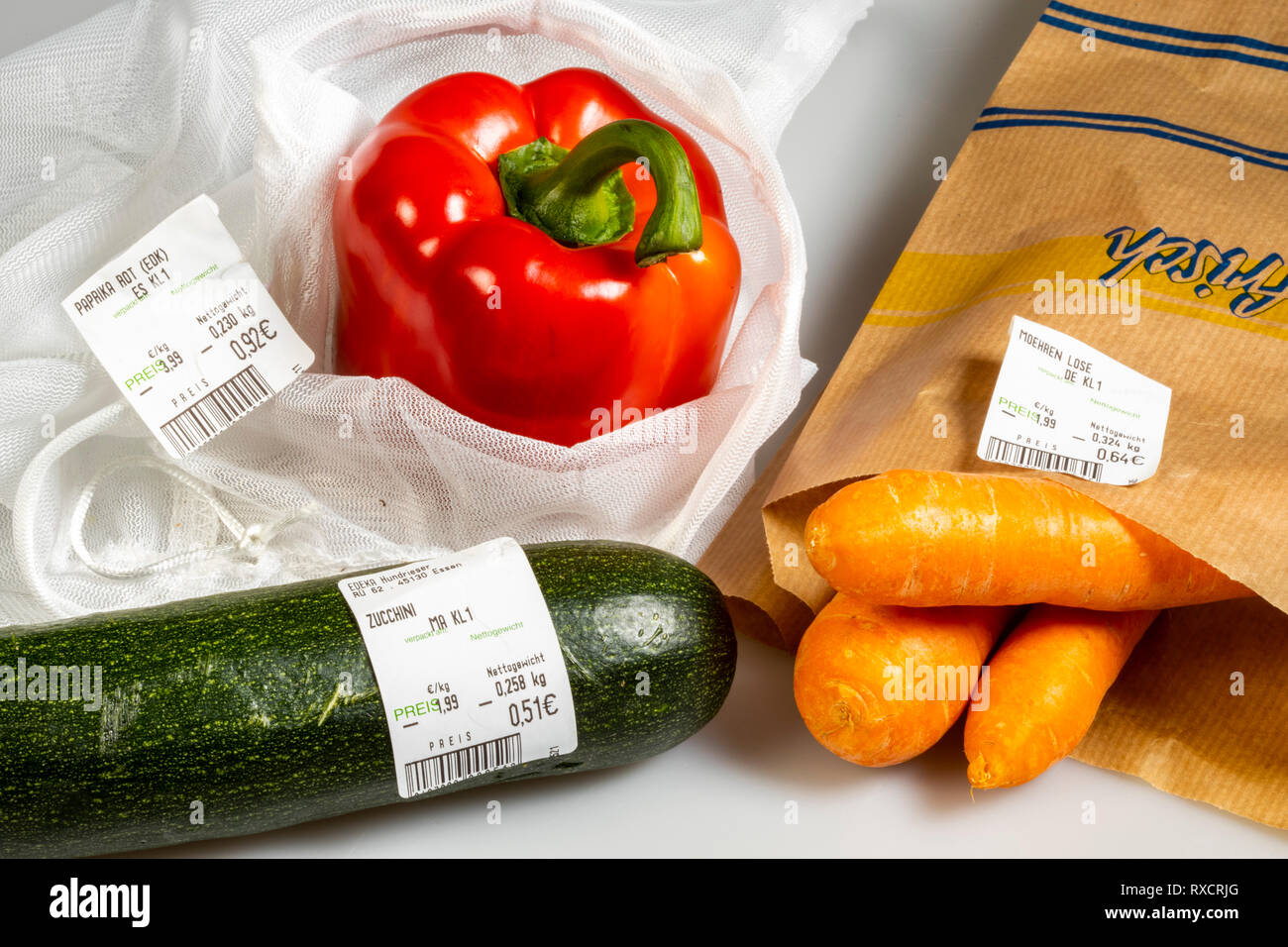 Verpackungen für Lebensmittel, Paprika in einer wiederverwendbaren Kunststoff net, Vermeidung von Kunststoffabfällen, Zucchini ohne Verpackung, Karotten in einer Papiertüte, Preis, Stockfoto