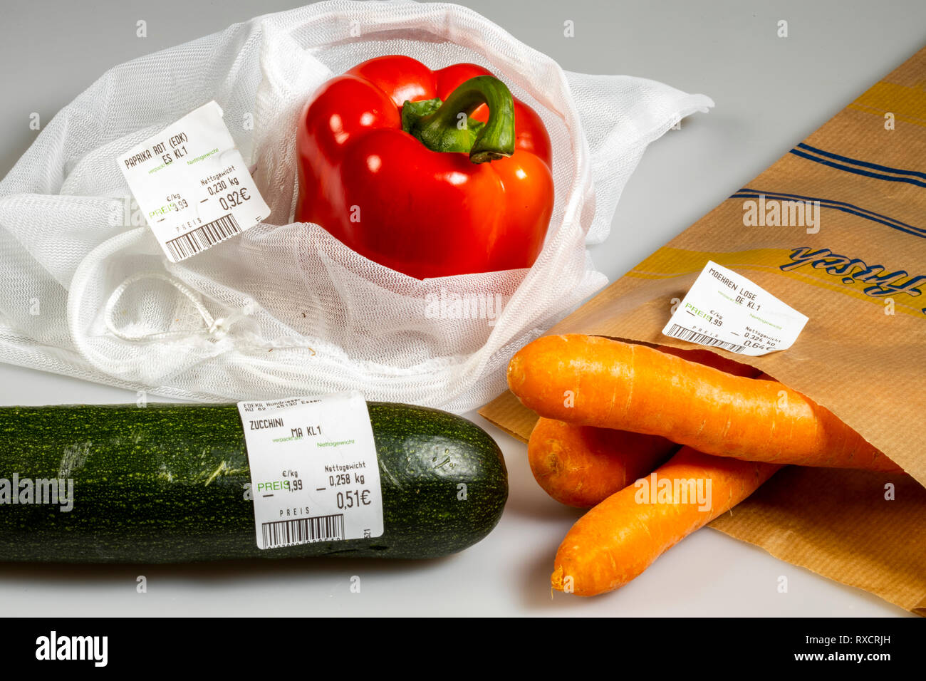 Verpackungen für Lebensmittel, Paprika in einer wiederverwendbaren Kunststoff net, Vermeidung von Kunststoffabfällen, Zucchini ohne Verpackung, Karotten in einer Papiertüte, Preis, Stockfoto
