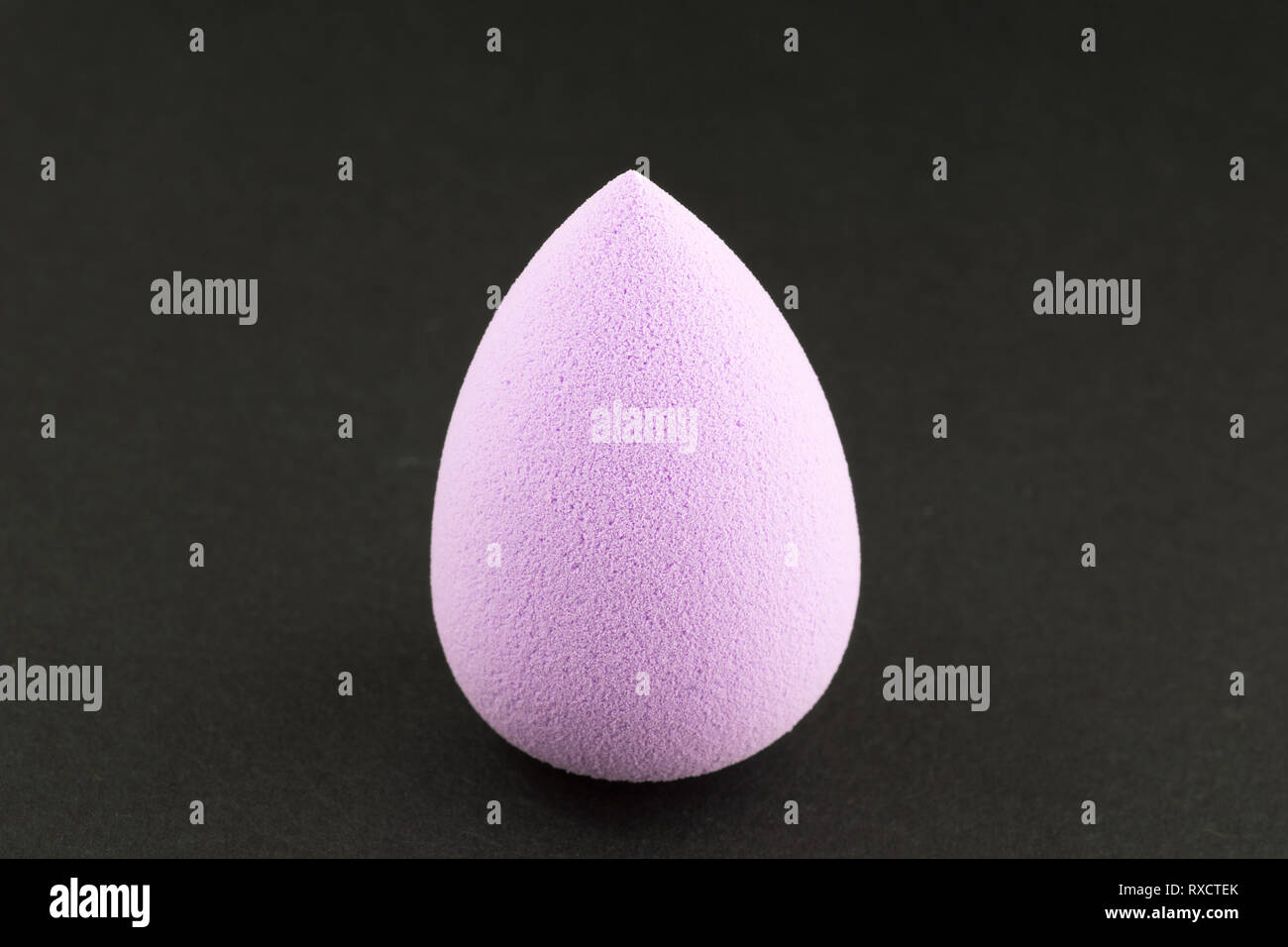 Schwamm für die Anwendung von Kosmetika im Gesicht auf schwarzem Hintergrund Stockfoto