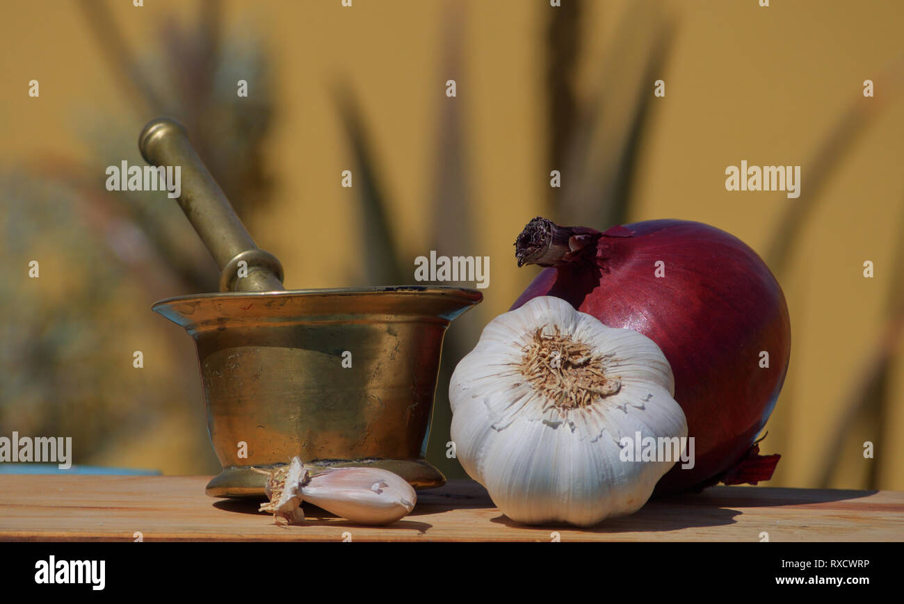 Stillleben mit alten Bronze Mörtel, lila Zwiebeln und Knoblauch Kopf Stockfoto