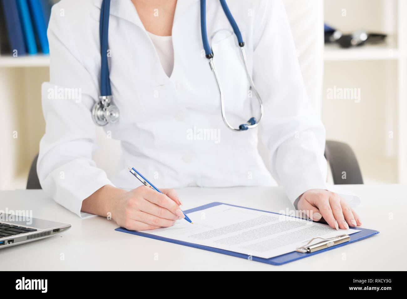 Arzt unterzeichnen Vertrag Dokument in klinischen Büro Stockfoto