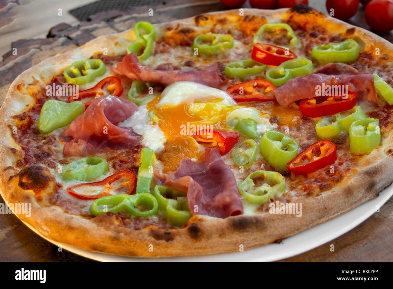 Pizza mit Tomatensoße, Schinken, Ei, frische grüne und rote Paprika ...