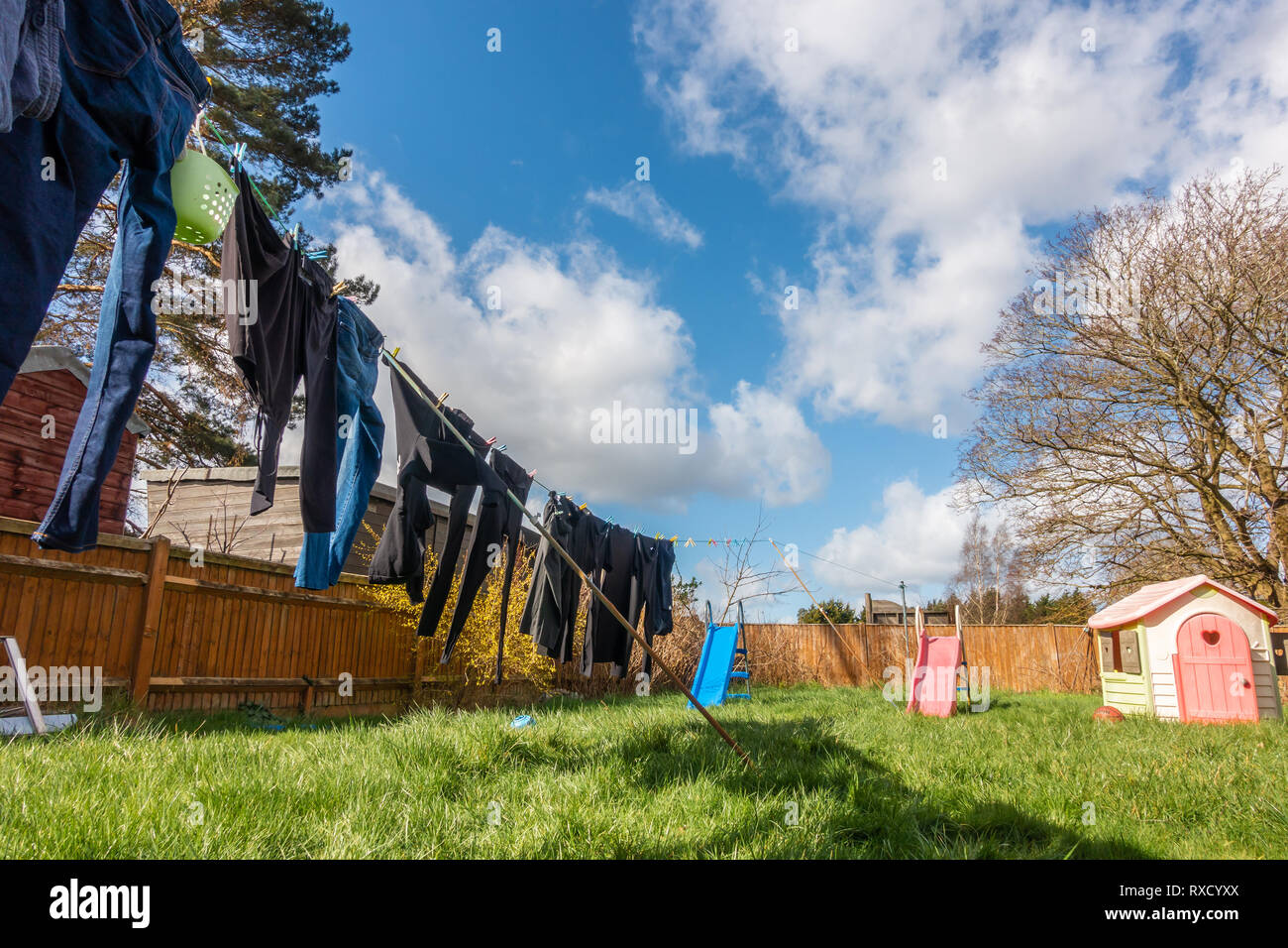 Kleidung draußen trocknen auf der Wäscheleine an einem windigen Tag mit gebrochenen Wolken und ein blauer Himmel Stockfoto