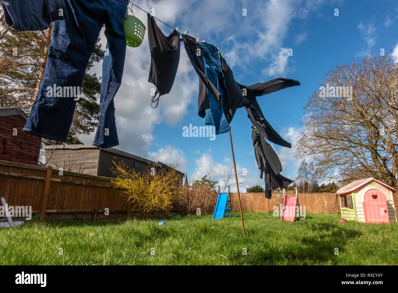 Kleidung draußen trocknen auf der Wäscheleine an einem windigen Tag mit gebrochenen Wolken und ein blauer Himmel Stockfoto