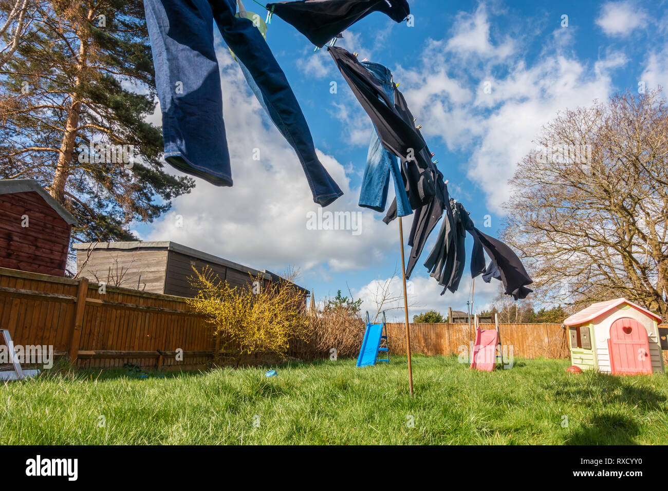 Kleidung draußen trocknen auf der Wäscheleine an einem windigen Tag mit gebrochenen Wolken und ein blauer Himmel Stockfoto