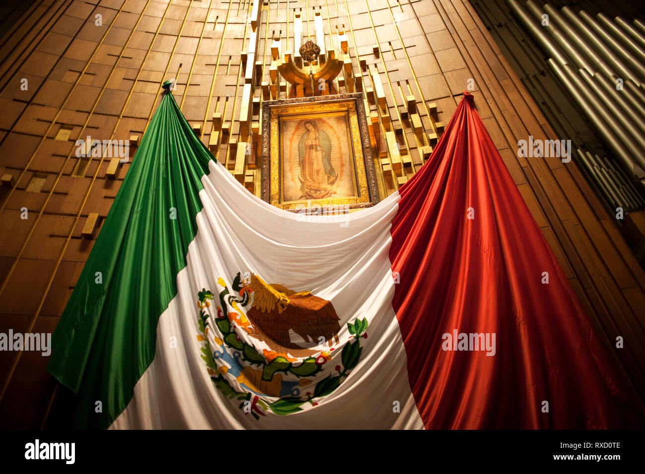Der Altar mit dem ursprünglichen Bild Unserer Lieben Frau von Guadalupe, verziert mit einer mexikanischen Flagge in der Basilika Nuestra Señora de Guadalupe in Mexiko Stadt, Mexic Stockfoto