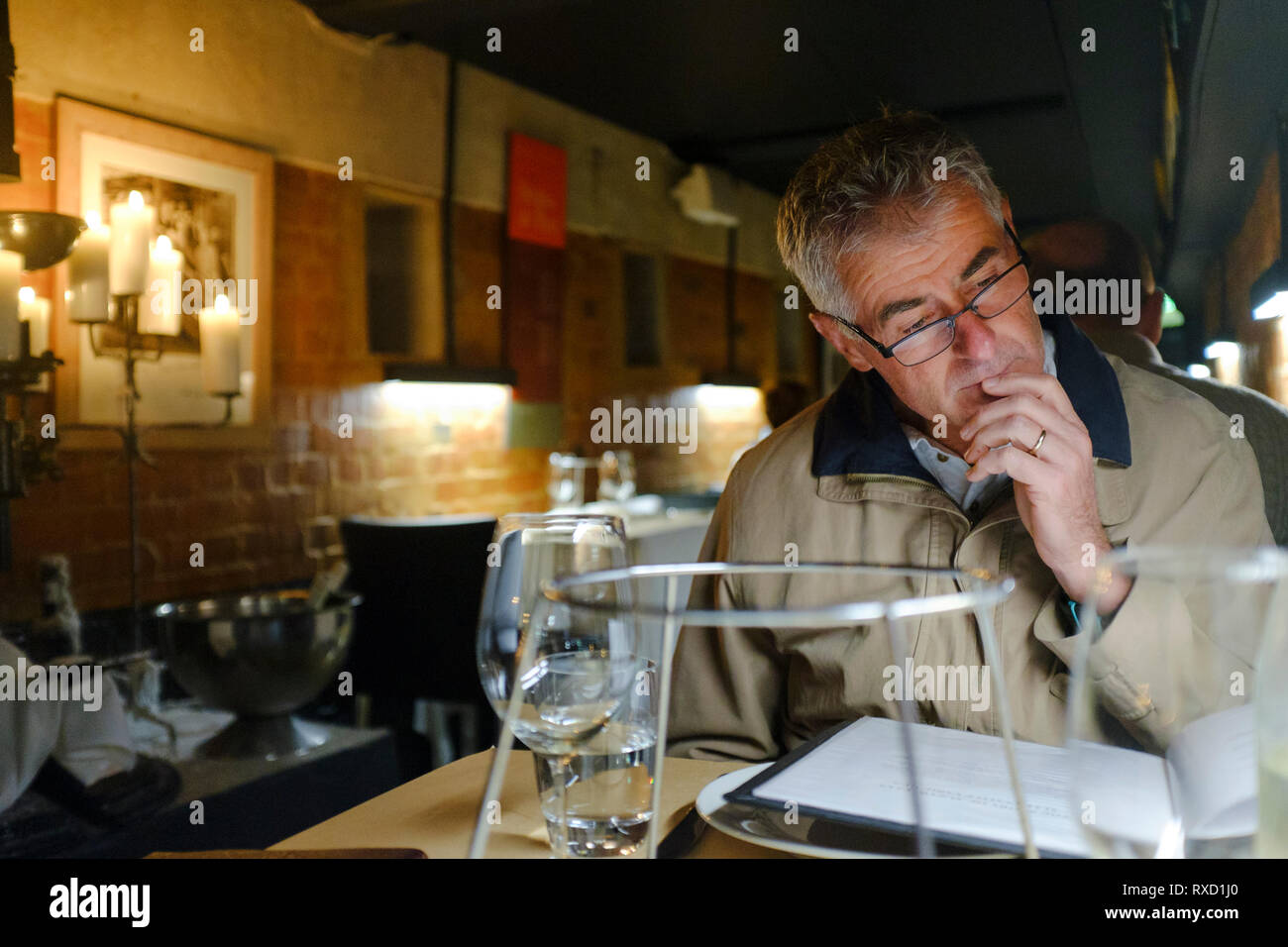 Mann mit Brille lesen Menü im Restaurant in Australien Stockfoto
