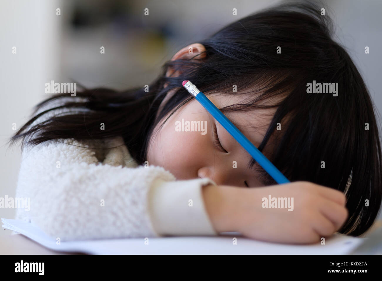 Asiatisches junges Kind Einschlafen während der Studie Stockfoto