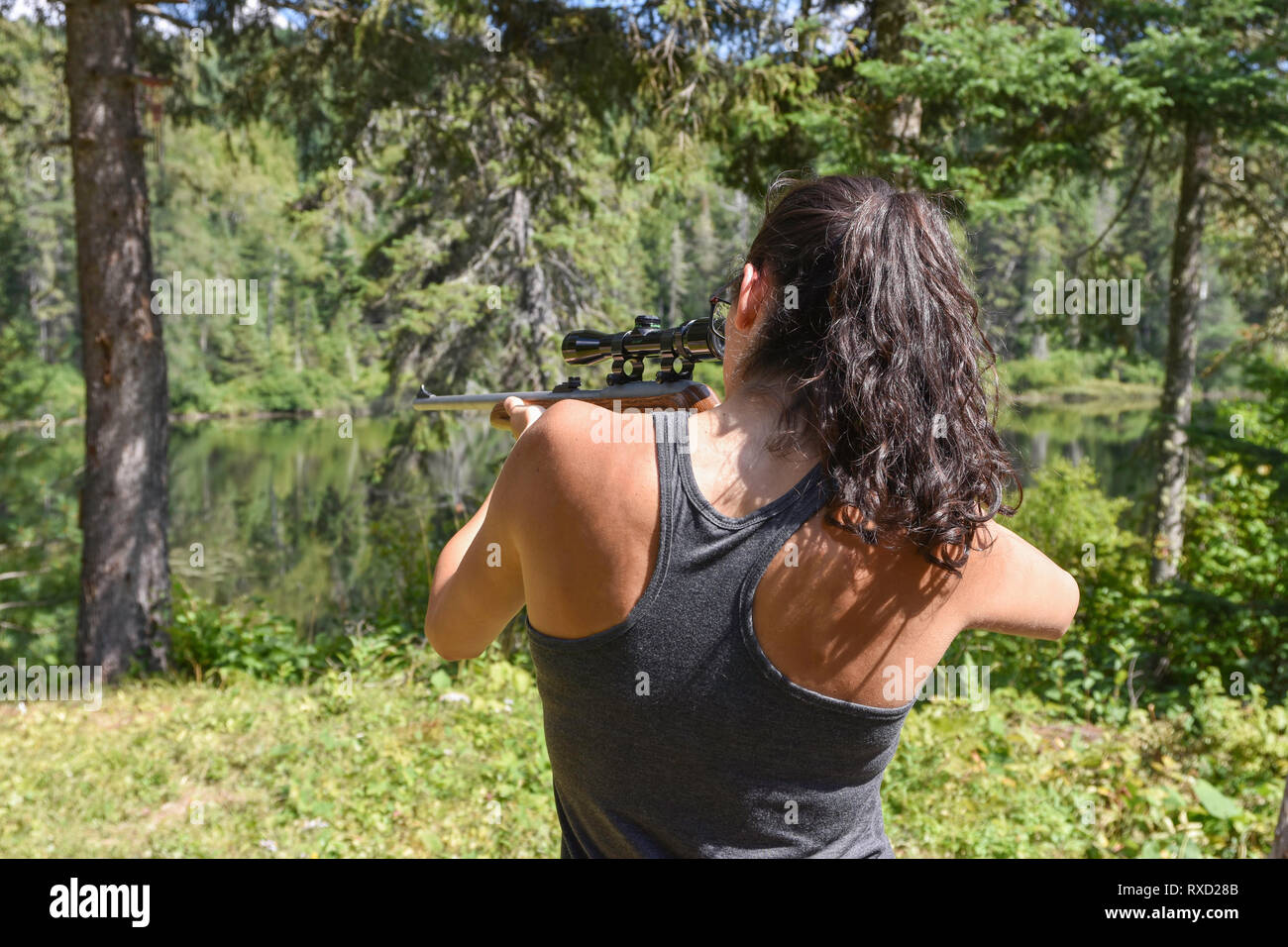 Die Frau mit dem Ziel, ein Gewehr an ein Ziel in einem Waldgebiet. Stockfoto