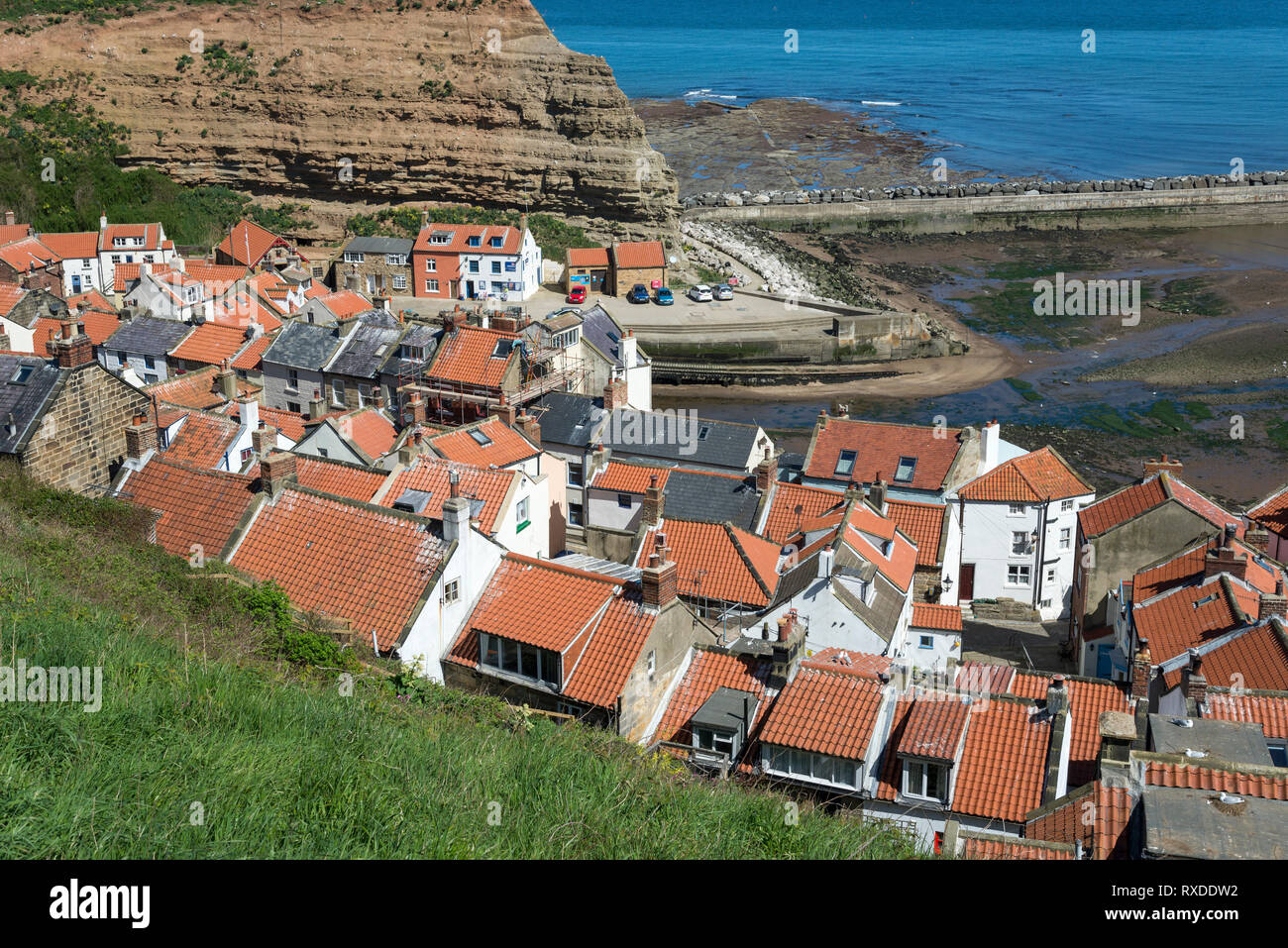 Die malerischen Küstenort Staithes, North Yorkshire, England. Den Blick über die roten Dächer zum Hafen. Stockfoto