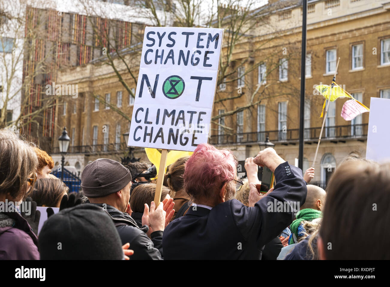 London, Großbritannien. 9 Mär, 2019. Aussterben Rebellion Rallye eine Demonstration in der Downing Street. Demonstranten halten das Banner, das System zu ändern, den Klimawandel nicht. Credit: AndKa/Alamy leben Nachrichten Stockfoto