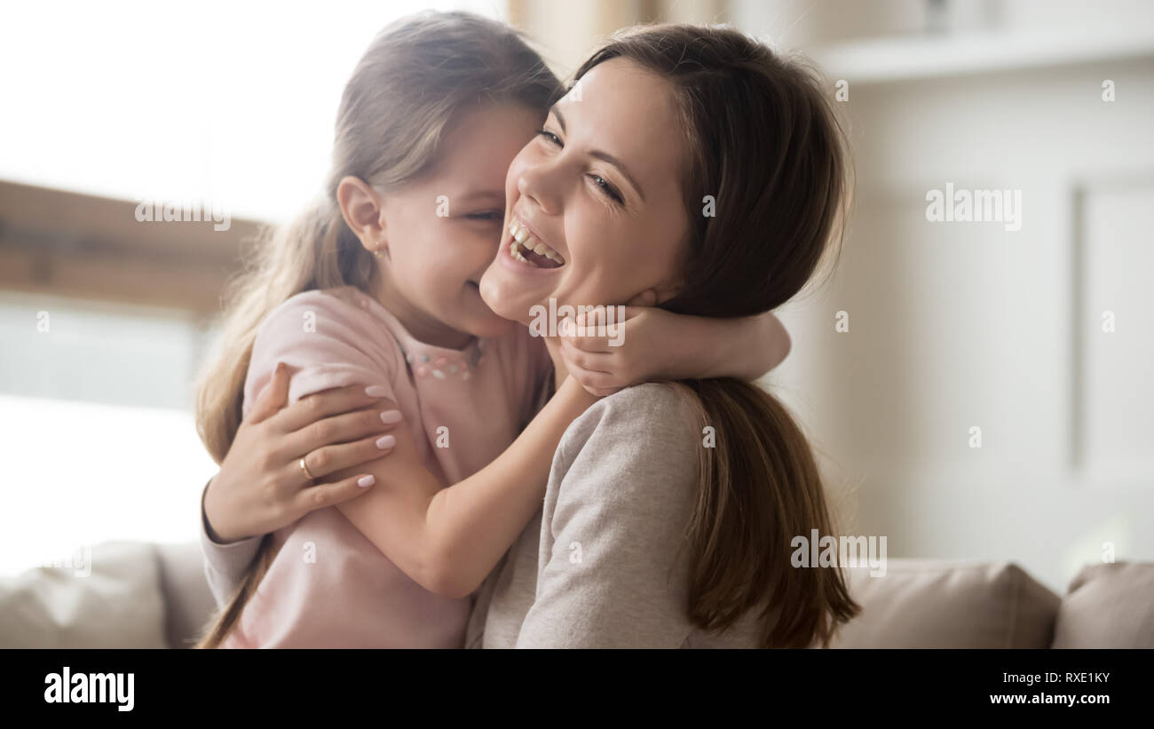 Liebevolle junge Mutter lachend umarmt lächelnd cute Funny kid Girl Stockfoto