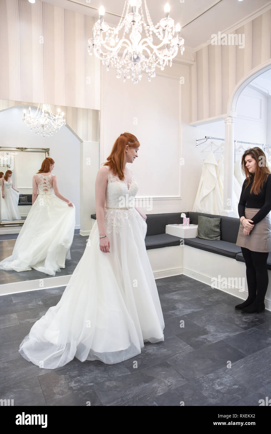 Ziemlich kaukasische Mädchen, das versuchte auf Hochzeit Kleider in einem gehobenen Bridal Shop. Stockfoto