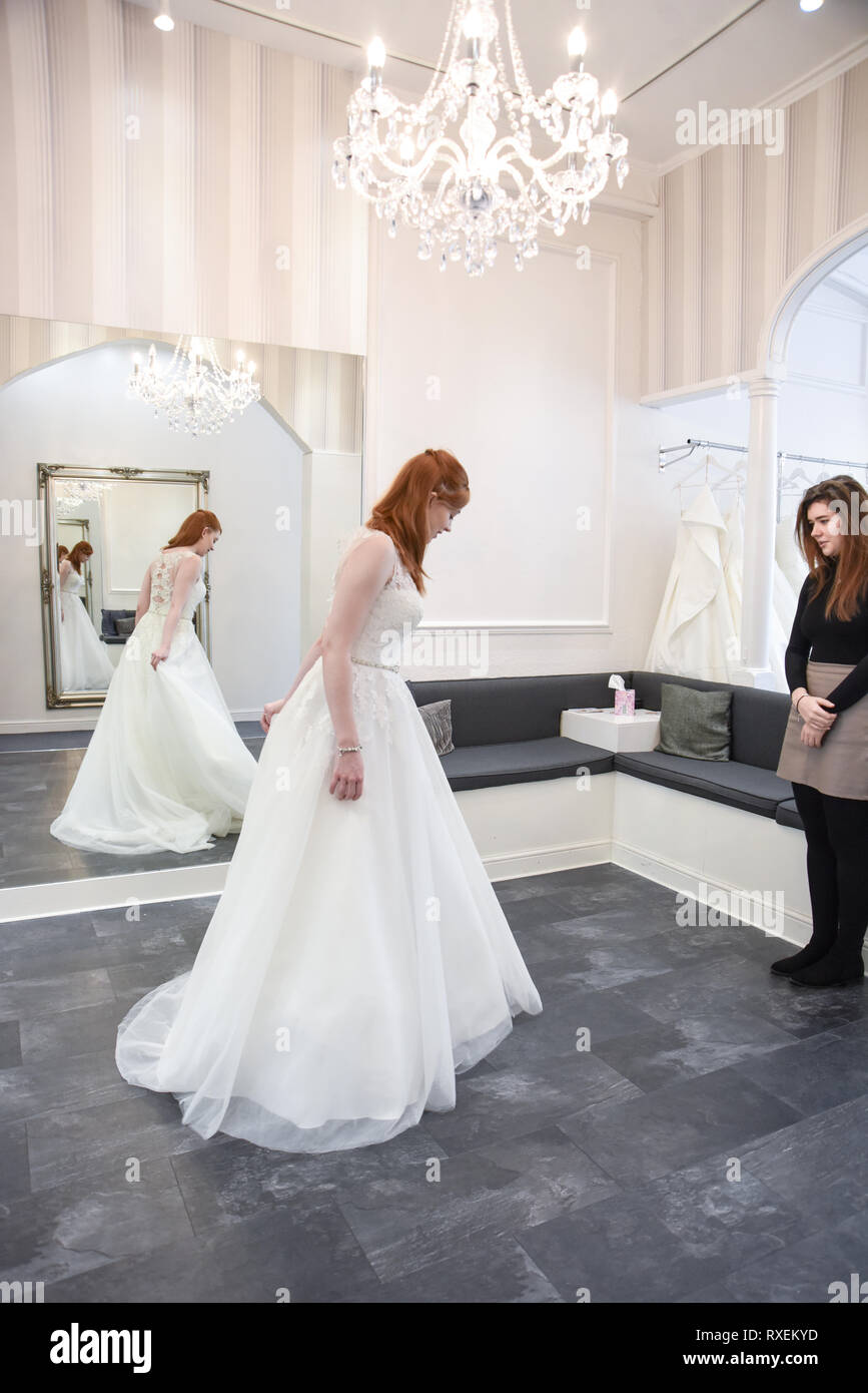 Ziemlich kaukasische Mädchen, das versuchte auf Hochzeit Kleider in einem gehobenen Bridal Shop. Stockfoto