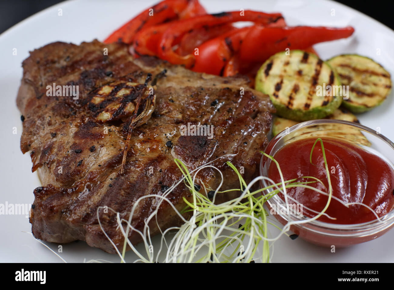 Rindfleisch Döner auf einer Platte mit gegrilltem Gemüse, Zucchini und Bulgarischen roten Pfeffer, mit Gruenen und Sauce eingerichtet Stockfoto