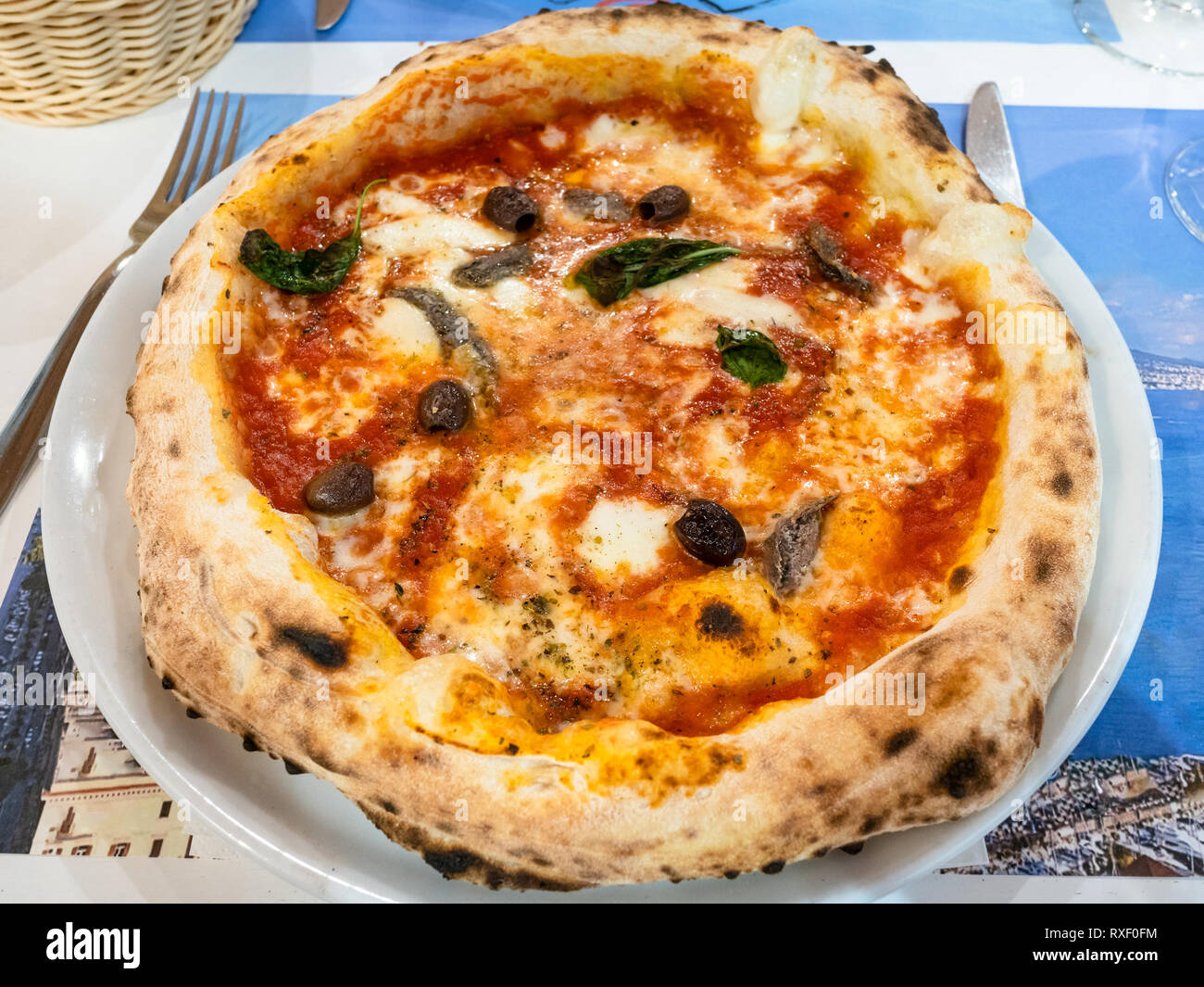 Traditionelle italienische Pizza Napoli mit Sardellen, Basilikum und ...