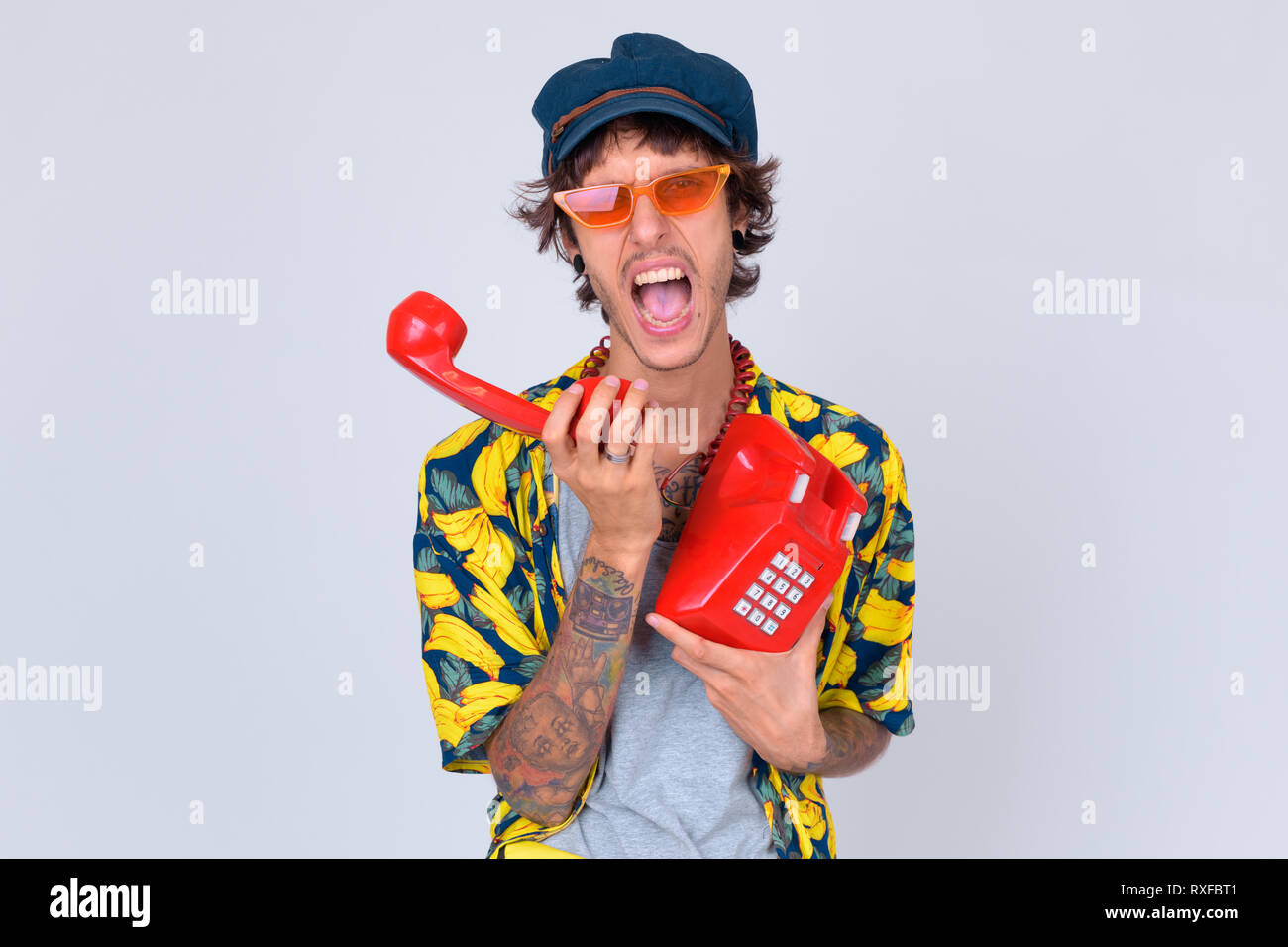 Portrait von wütenden jungen rebellischen Menschen schreien am alten Telefon Stockfoto