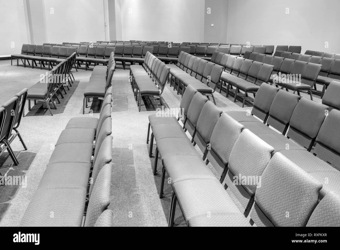 Horizontale schwarze und weiße Schuß von leeren Auditorium, der an der gegenüberliegenden Seite suchen. Stockfoto