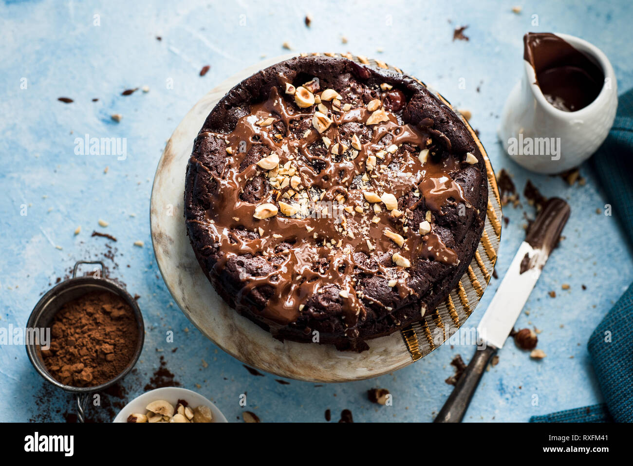 Schokoladenkuchen auf einer runden Platte mit gehackten Haselnüssen Stockfoto