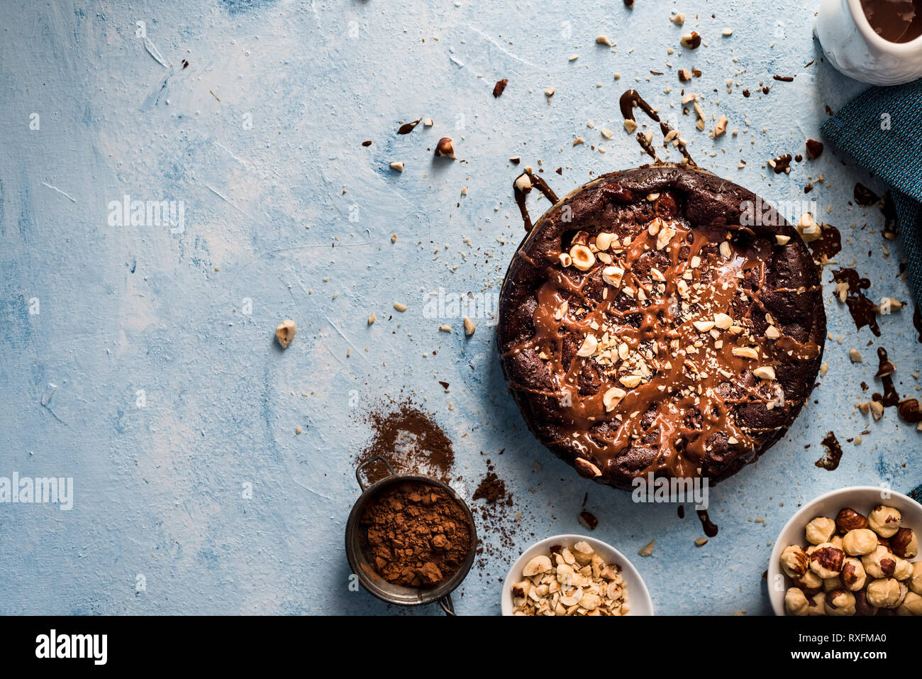 Schokoladenkuchen mit Haselnüsse auf einem blauen strukturierten Hintergrund und eine Kopie Raum Stockfoto