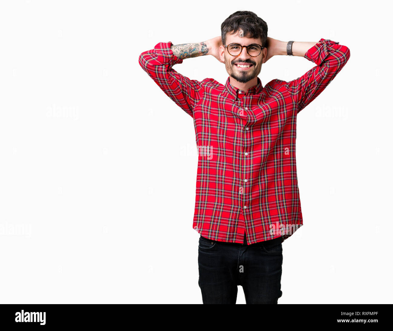 Junger stattlicher Mann mit Brille über isolierte Hintergrund Entspannung und Stretching mit Armen und Händen hinter dem Kopf und Hals und lächelte glücklich Stockfoto