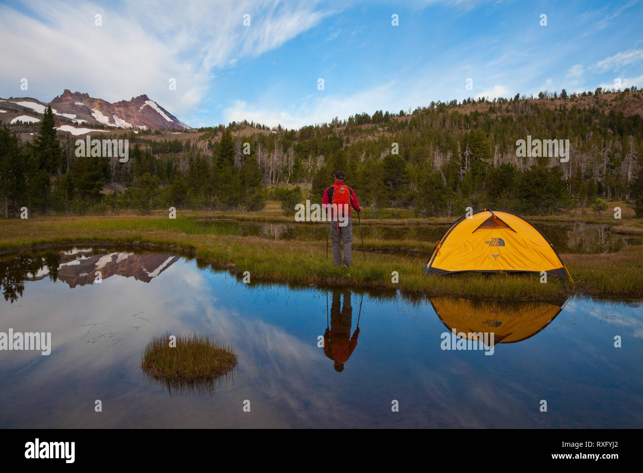 Wanderer und Zelt in einem Alpinen See in der Nähe von Broken Top Mountain außerhalb Schlaufe Oregon widerspiegelt Stockfoto