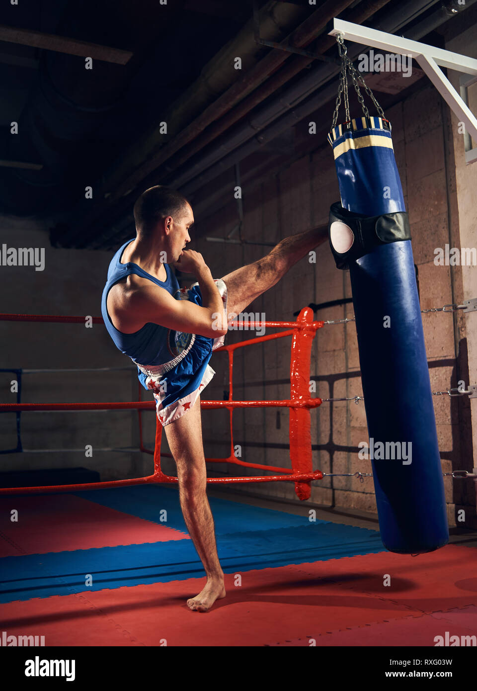 Professionelle kickboxer Mann hartem Training Kickboxen und Vorbereitung  auf Kampf, Tritte und Stanzen schwere Boxsack in der Nähe des Ring im  Health Club Stockfotografie - Alamy