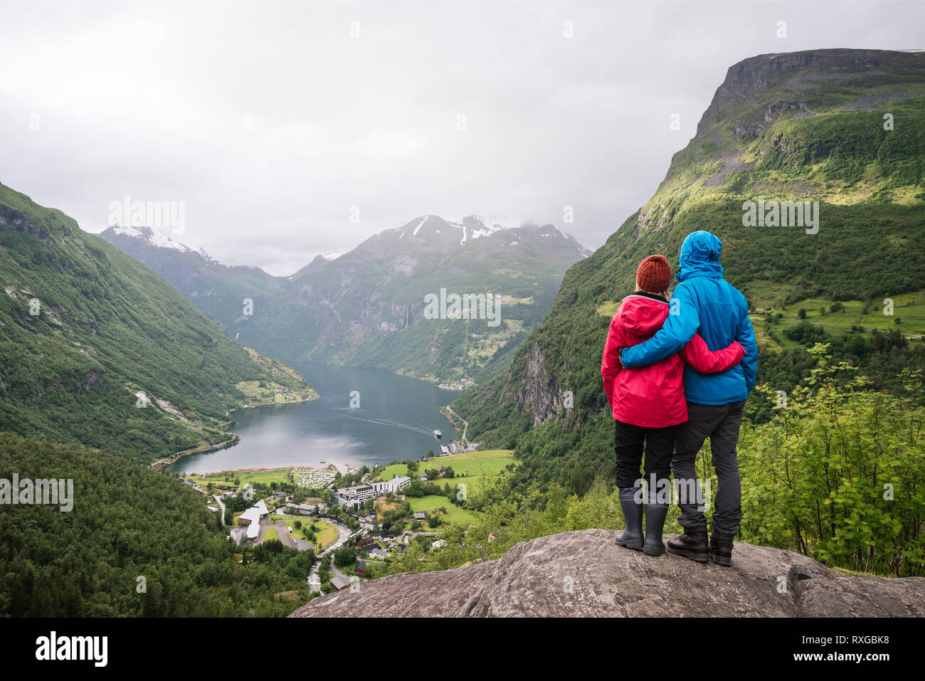 Sehenswürdigkeiten in Norwegen. Ein junges Paar genießen Sie eine herrliche Aussicht auf die Berge und den Fjord. Touristische Dorf Geiranger und den Geirangerfjord Stockfoto