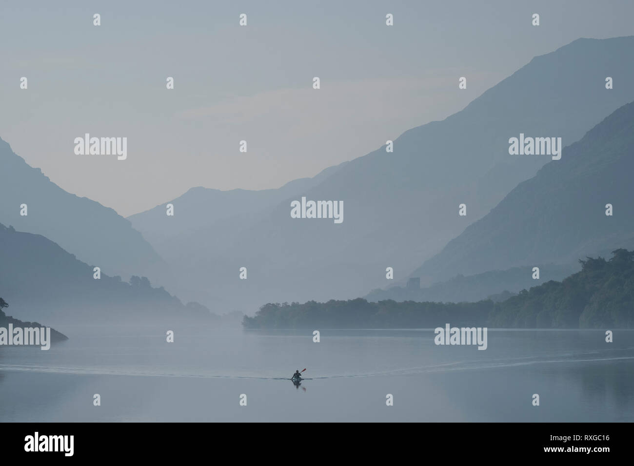 Schattierungen von Grau, am frühen Morgen Kanufahrer auf Llyn Padarn durch die Llanberis Pass, Snowdonia National Park, North Wales, UK gesichert Stockfoto