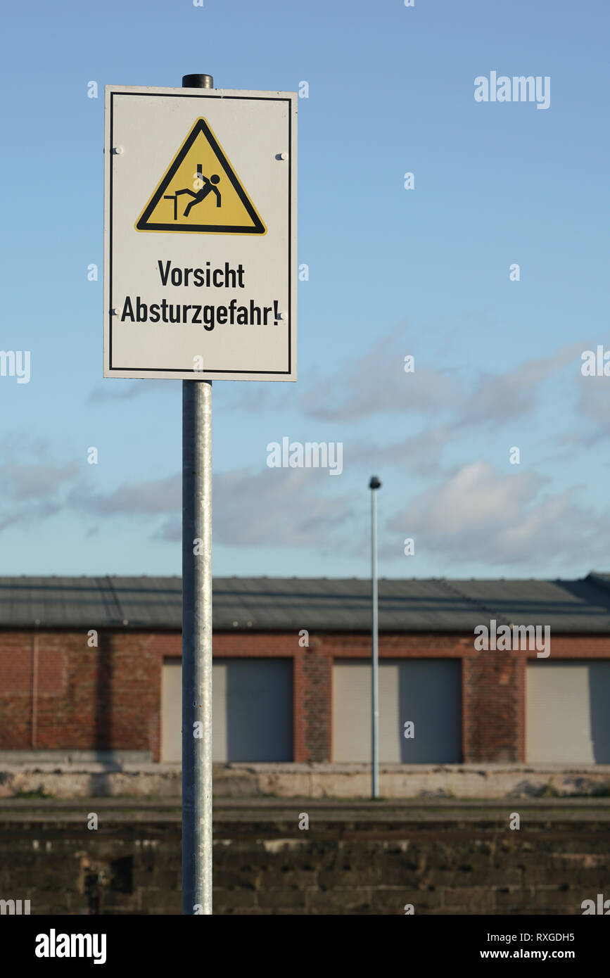 Schild mit der Aufschrift 'Vorsicht Gefahr des Absturzes" im Hafen von Magdeburg. Stockfoto