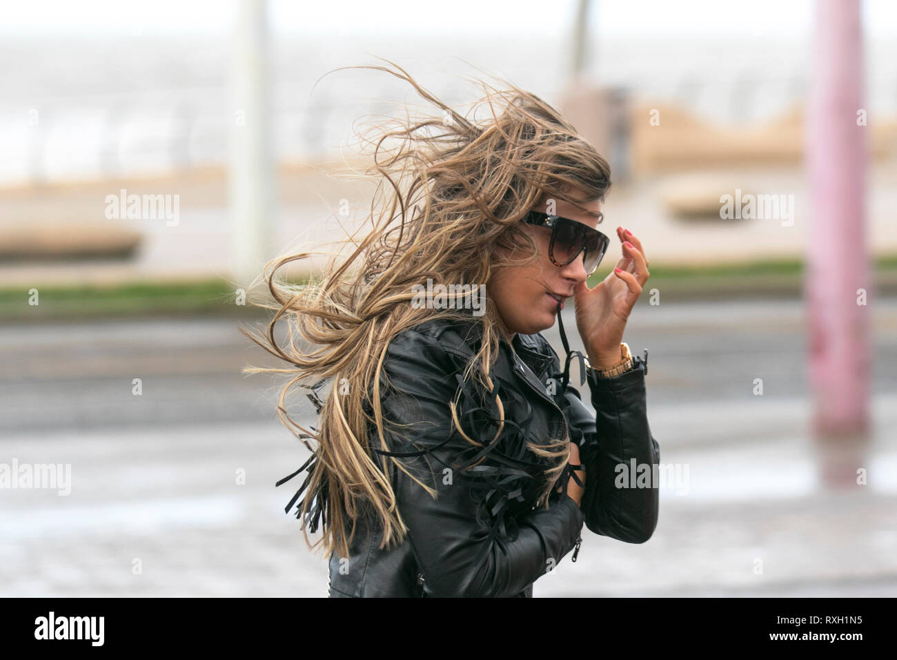 Blackpool, Großbritannien. 10. März, 2019. Strong gale force Winde an der Küste. Shopper sind windswept als der starke Stürmische Winde fegen durch die Innenstadt. Wetter Warnungen haben sich über den Nordwesten von England für schwere Böen und Starkregen über das Wochenende ausgestellt wurde. . Credit: MediaWorldImages/Alamy leben Nachrichten Stockfoto