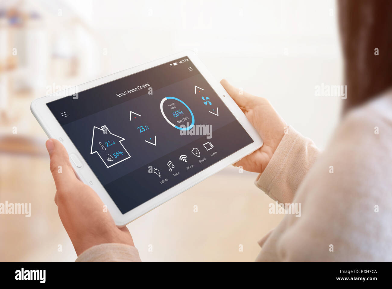 Moderne Home Control App mit flacher Oberfläche auf Tablet Display. Frau mit Tablet. Sun Licht im Hintergrund. Close-up. Stockfoto