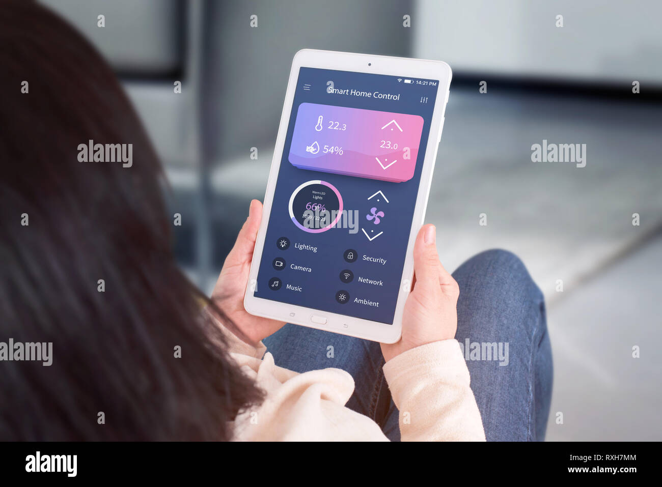 Smart Home Control Automation app Konzept. Frau mit Tablet mit modernen Flachbild desing app Wohnzimmer Temperatur, Belüftung, Beleuchtung. Stockfoto
