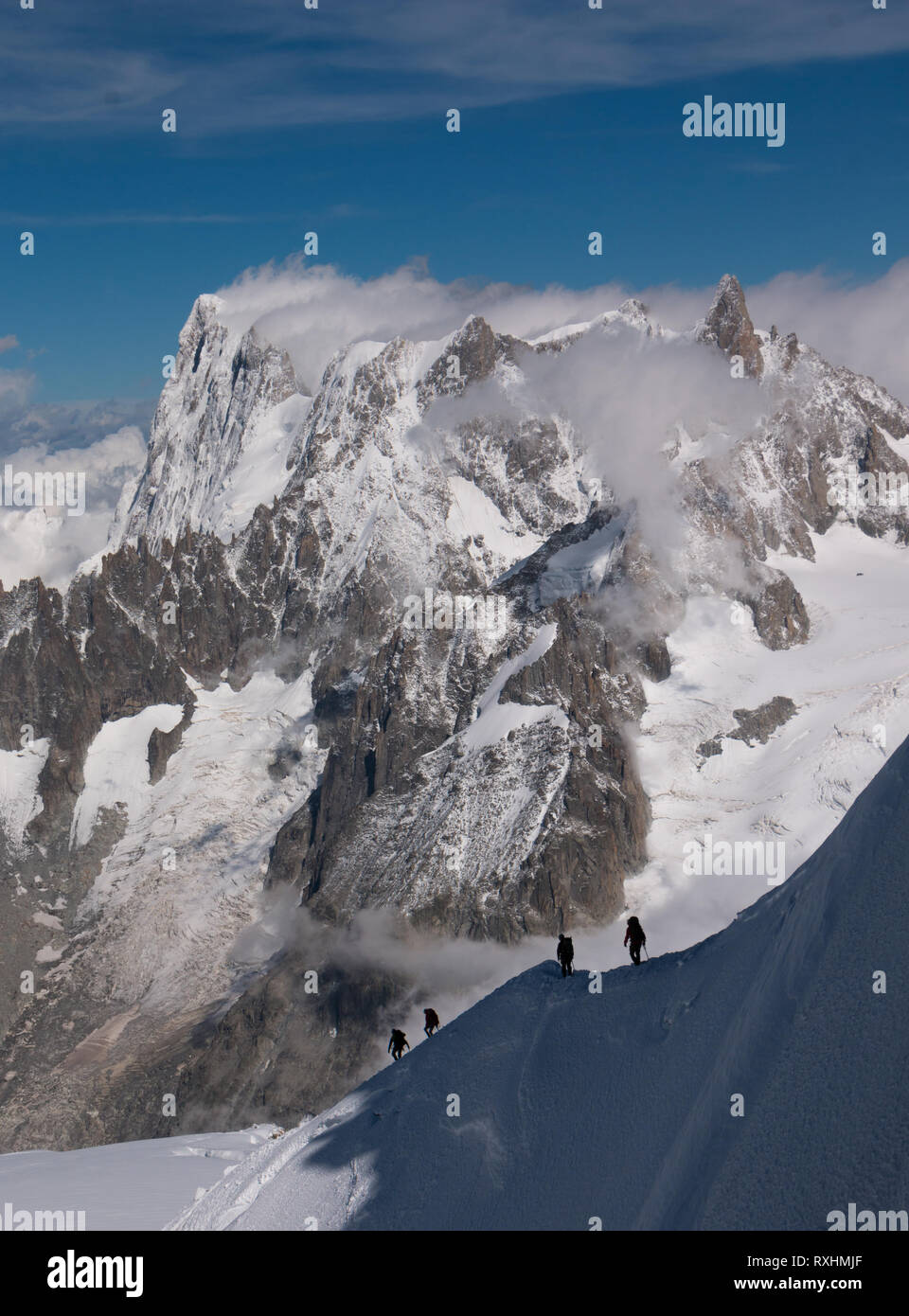 Vier mountaineerers auf dem Weg zum Mont Blanc, der höchste Berg der Alpen. Beeindruckende Bergkette im Hintergrund. Stockfoto