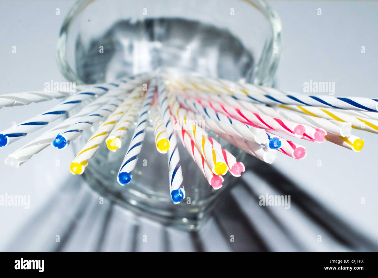 Bunte klebt auf einem Glas mug, abstrakte farbige Sticks Stockfoto