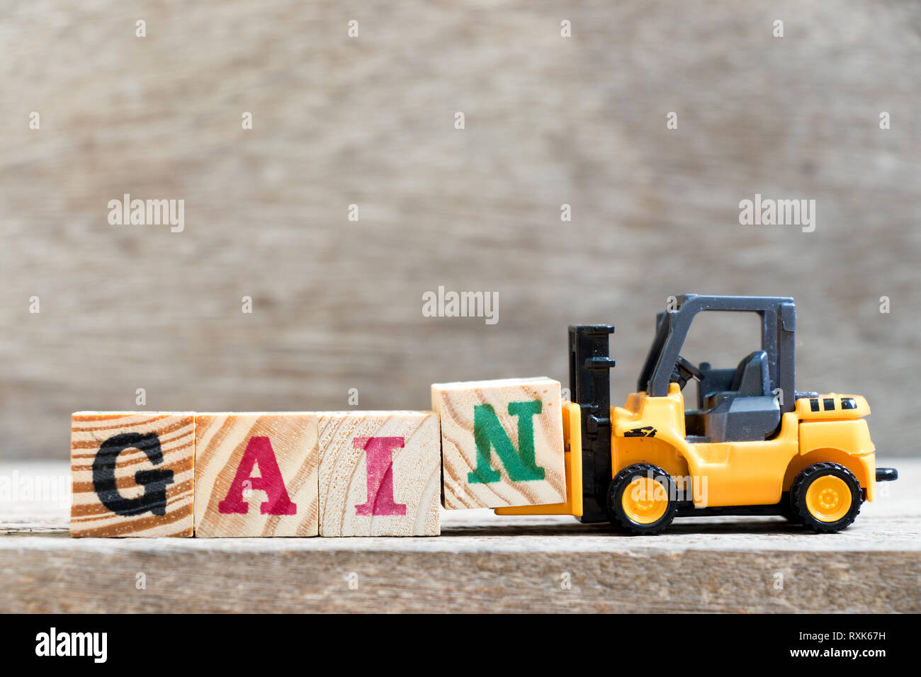 Spielzeug Gabelstapler halten schreiben Block N in Wort Gewinn aus Holz Hintergrund Stockfoto