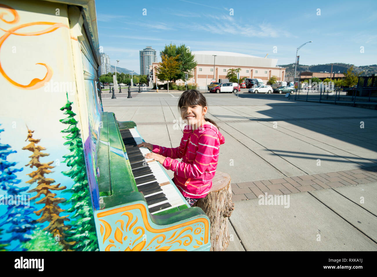 Ein junges Mädchen spielt eine öffentliche Klavier in Kelowna, British Columbia, Kanada Stockfoto