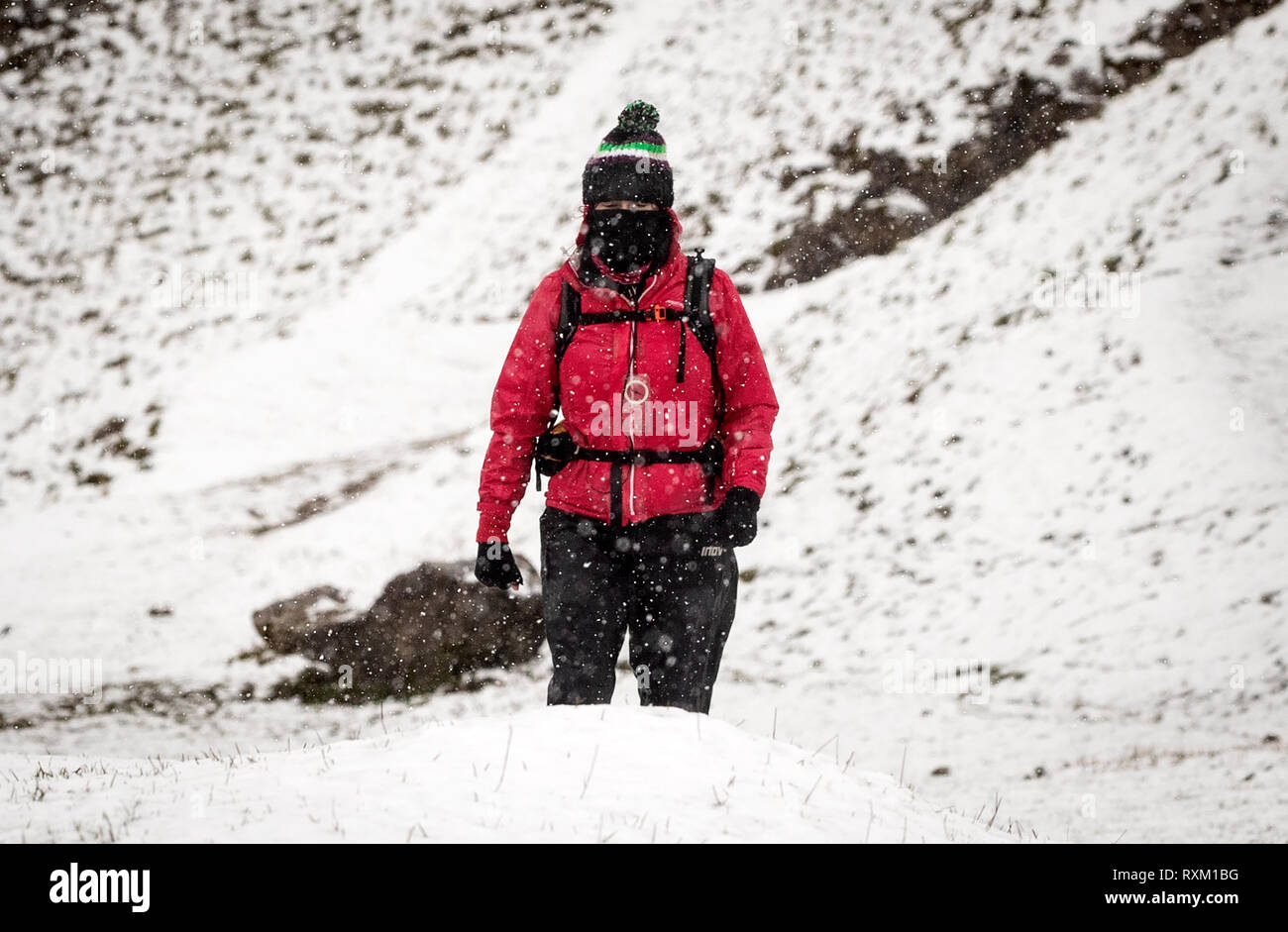 Ein Wanderer in Schnee auf Winnats Pass im Peak District, Derbyshire, wie Wetter Warnungen sind in ganz Großbritannien. Stockfoto