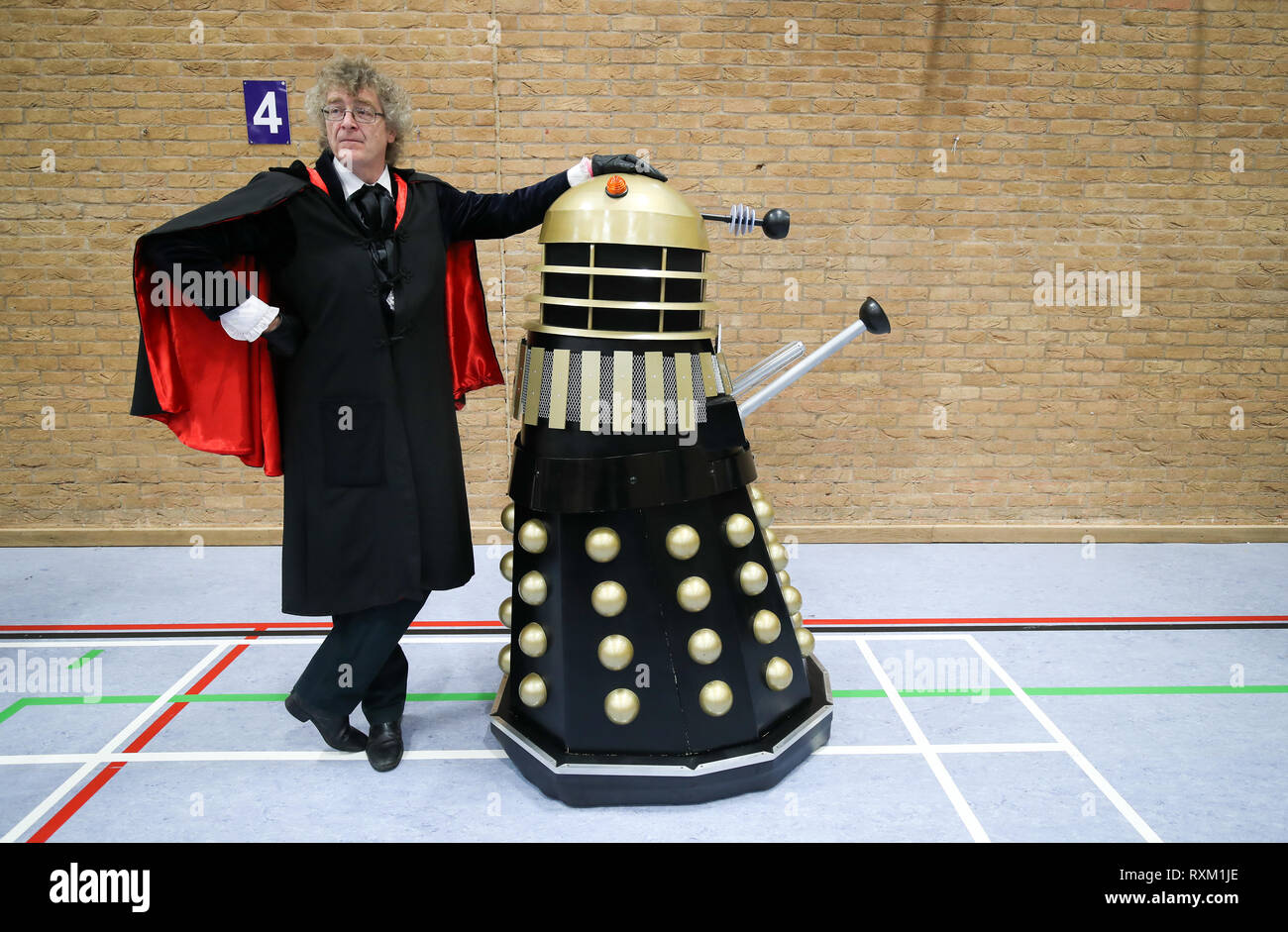 Ein Fan von Doctor Who wartet mit ein Dalek, bevor ein weltrekordversuch Für die meisten Daleks in einem Ort während der 'The Gathering', ein Arzt, der themed Charity Event an der Olympiade Freizeitzentrum in Chippenham, Wiltshire. Stockfoto