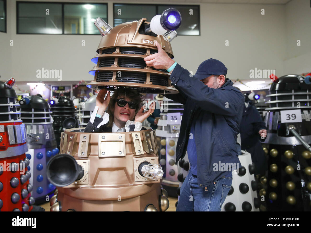 Oben ein Dalek wird auf seinen Fahrer gesenkt wie Daleks sind zusammen in einem Zimmer versammelt vor ein weltrekordversuch Für die meisten Daleks in einem Ort während der 'The Gathering', ein Arzt, der themed Charity Event an der Olympiade Freizeitzentrum in Chippenham, Wiltshire. Stockfoto