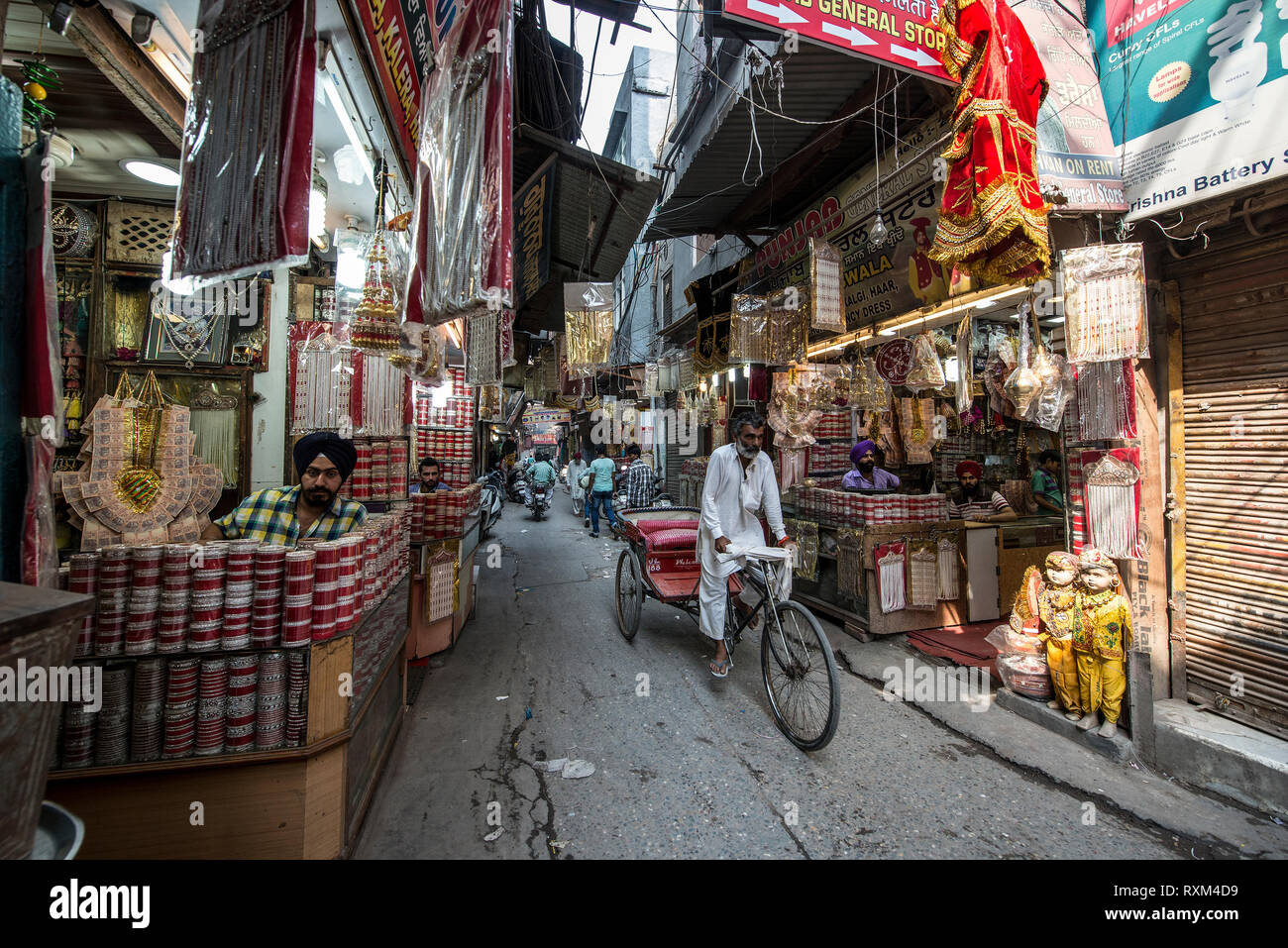 Indien, AMRITSAR, Cycle rickshaw vorbei durch einen engen Basar Straße mit kleinen Geschäften Stockfoto