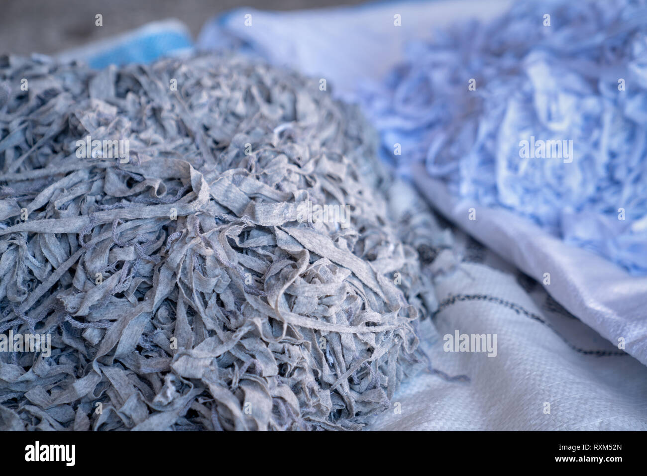 Fabric scraps, alte Kleidung und Textilien sind in Streifen warten auf Papierkorb Schnitt Stockfoto