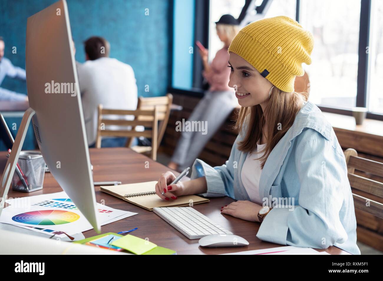 Portrait Of Happy and Geschäftsfrau, die an ihrem Arbeitsplatz im Büro Stockfoto