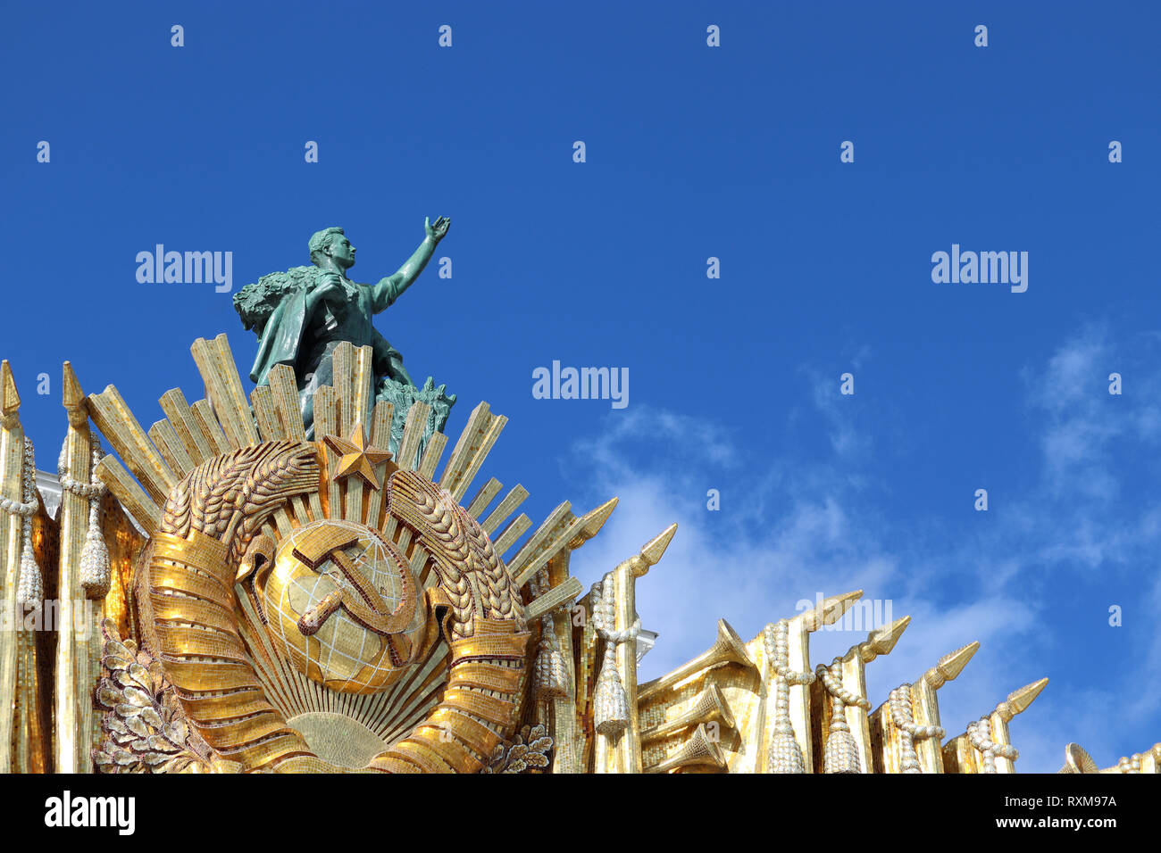 Sowjetische Symbole, UDSSR Wappen und Skulptur eines Arbeitnehmers auf der Fassade der Zentrale Pavillon auf Vdnh in Moskau gegen den blauen Himmel an einem sonnigen Tag Stockfoto