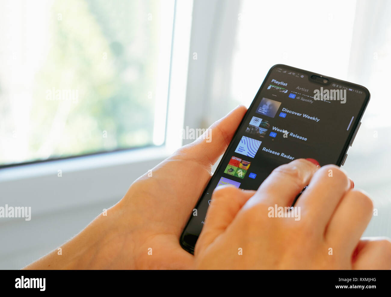 Spotify Musik App hand smartphone Wiedergabeliste scrollen Stockfoto